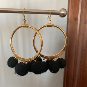 Gold hoop earrings with black wool felt drops